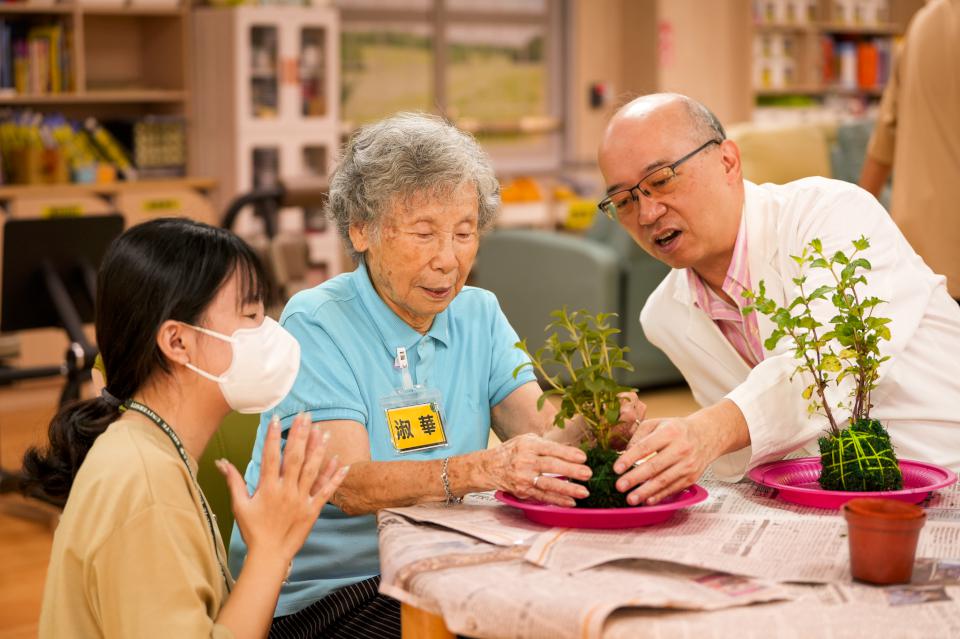 樹科大行管系16師生前進聖功醫院失智日照中心 陪伴長者體驗手作水苔球樂趣